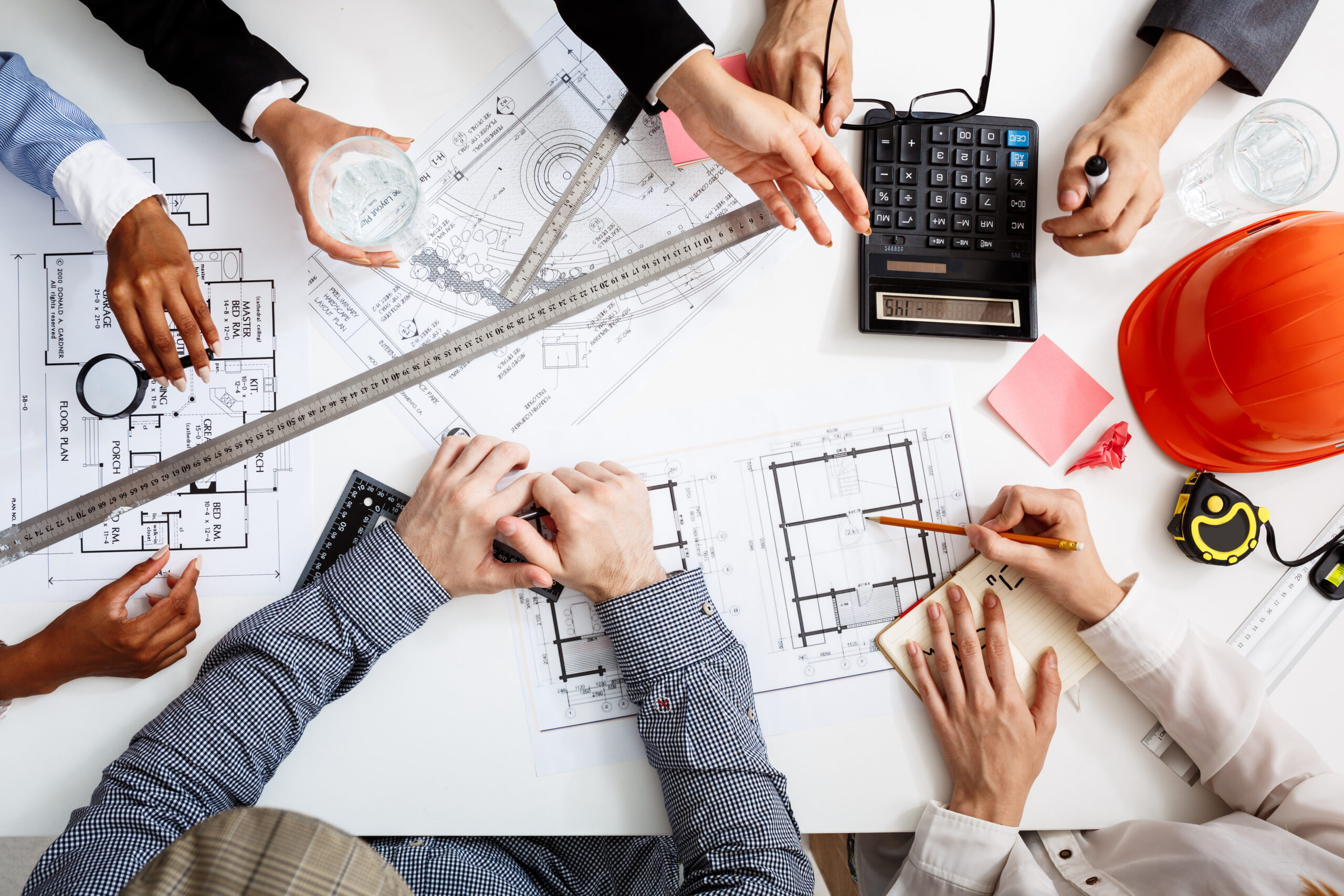 Picture of businessmen's hands on white table with documents and drafts